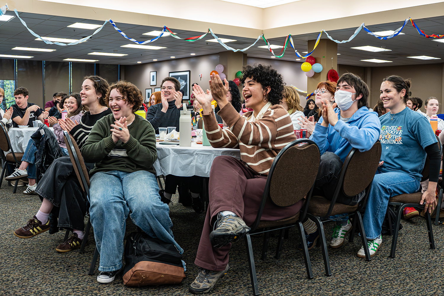 A group of students clapping at a Willamette event