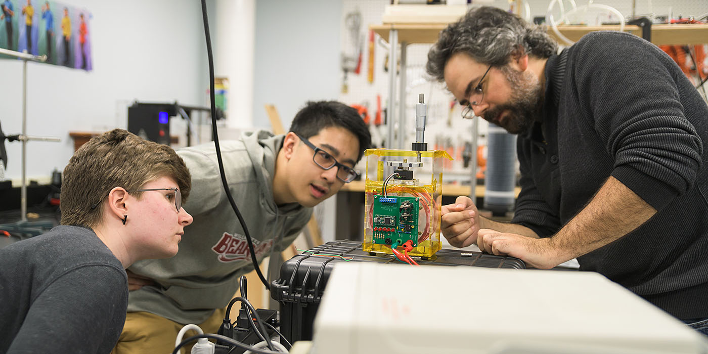 Willamette students and a professor study in a lab.