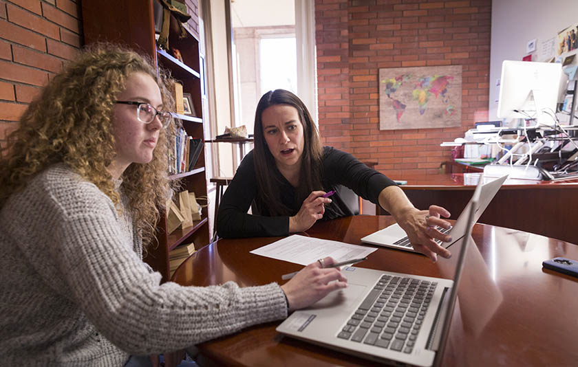 A career advisor talking to a Willamette student in a brick building