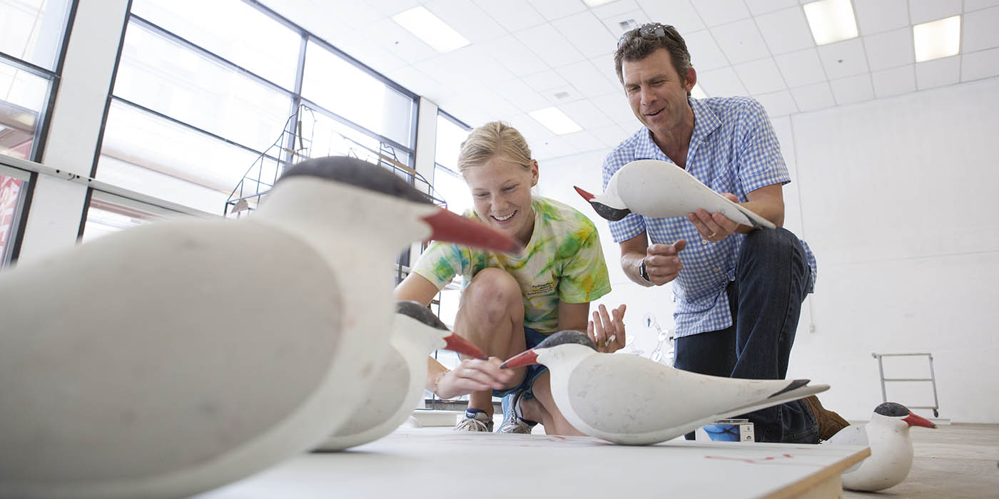 A Willamette professor and student studying birds in a classroom