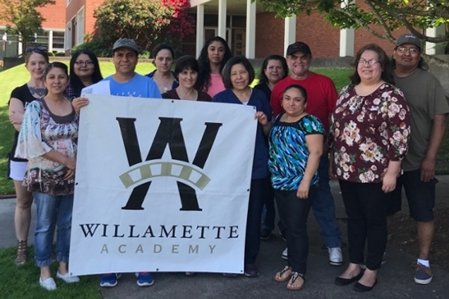 Parents holding a Willamette Academy sign.