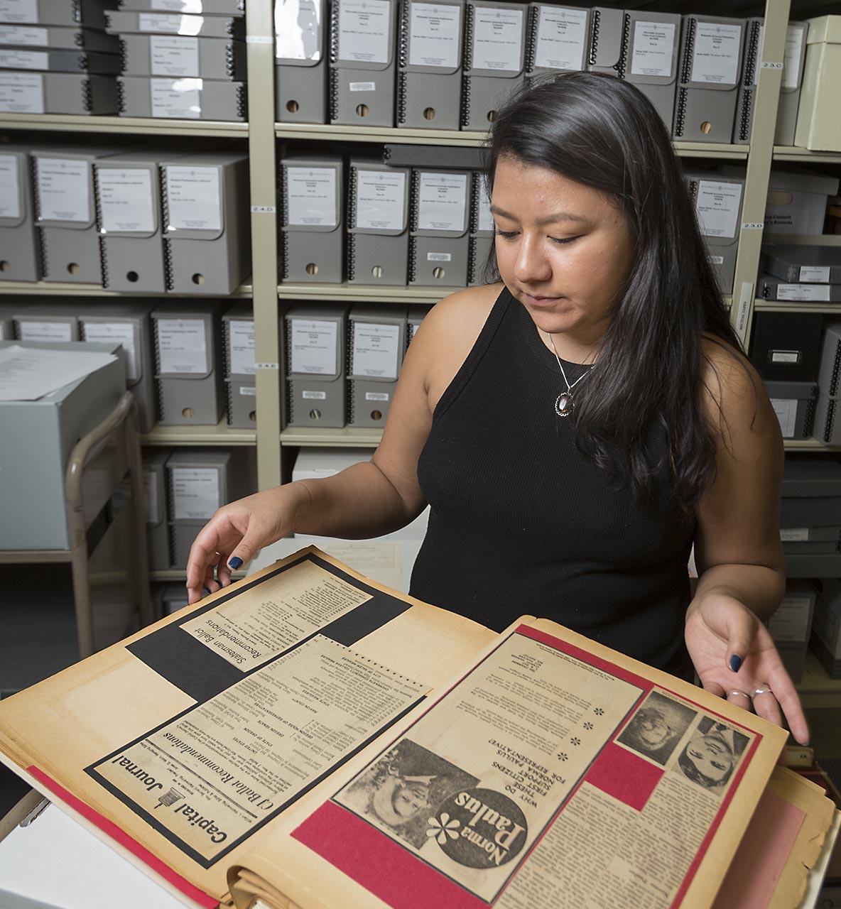 Willamette student looking through an old book in the archives