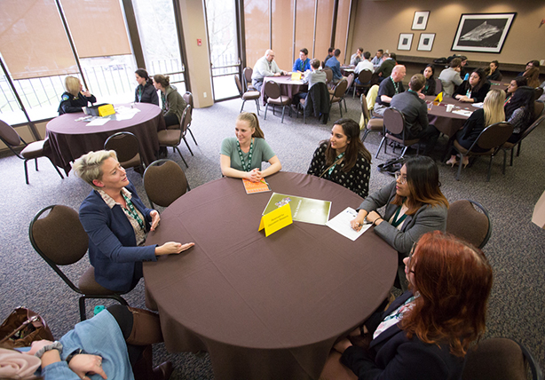 A group of people discussing around a circular table