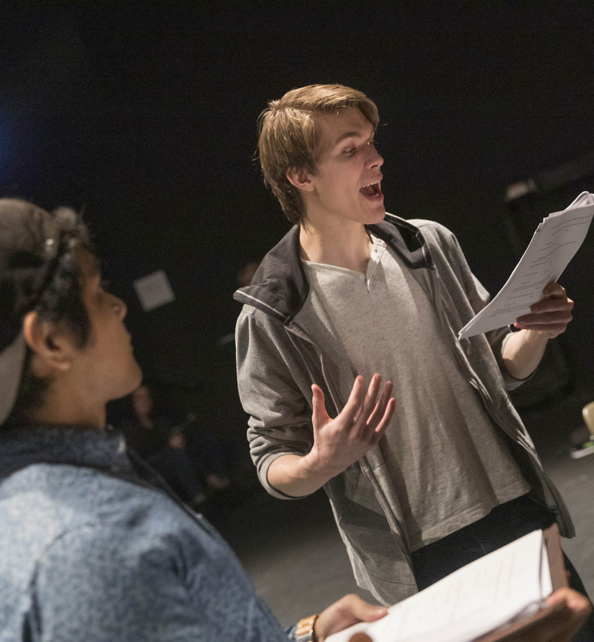 Two Willamette students practicing acting, one is reading off of a script.