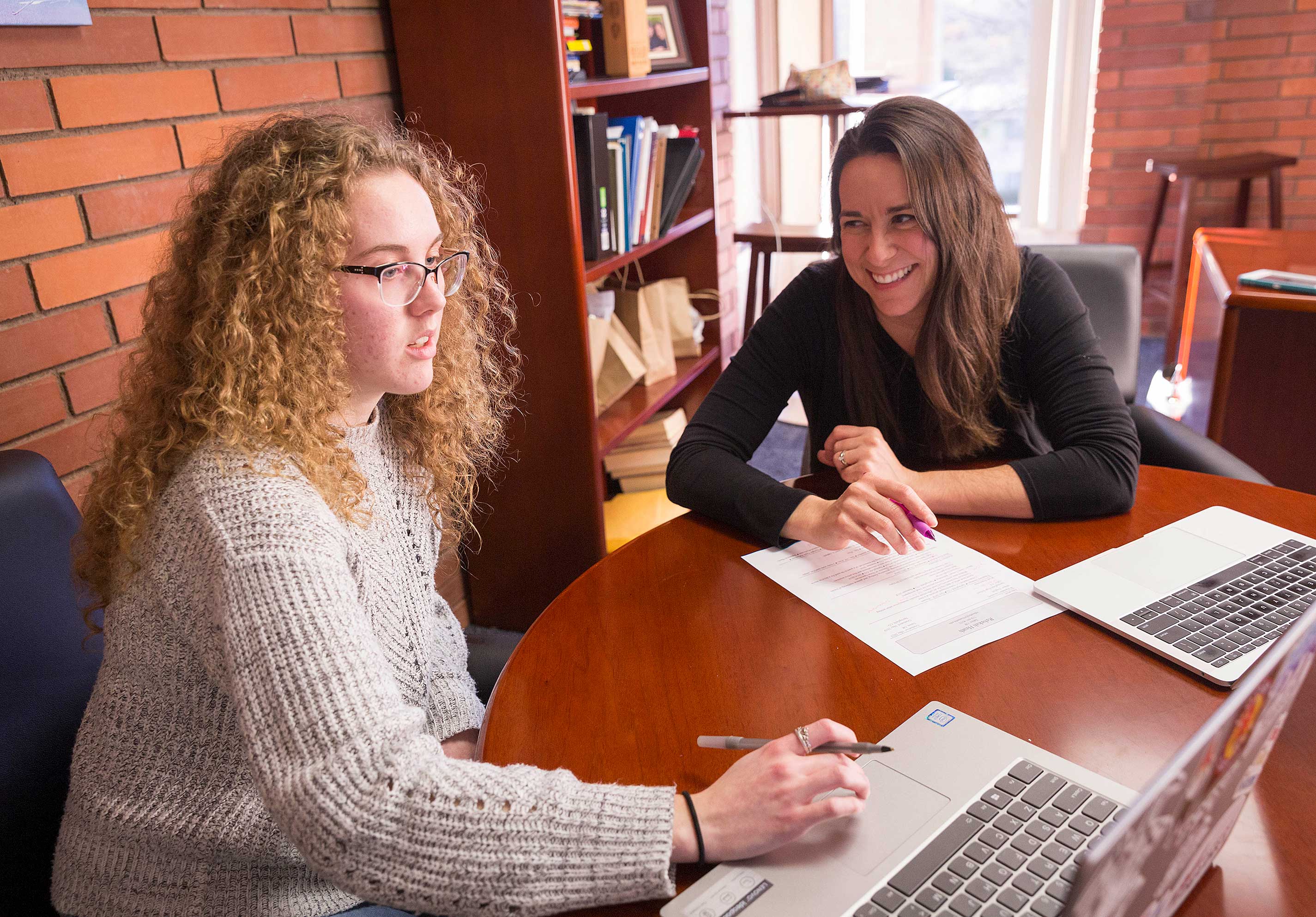Two students studying behind their laptops