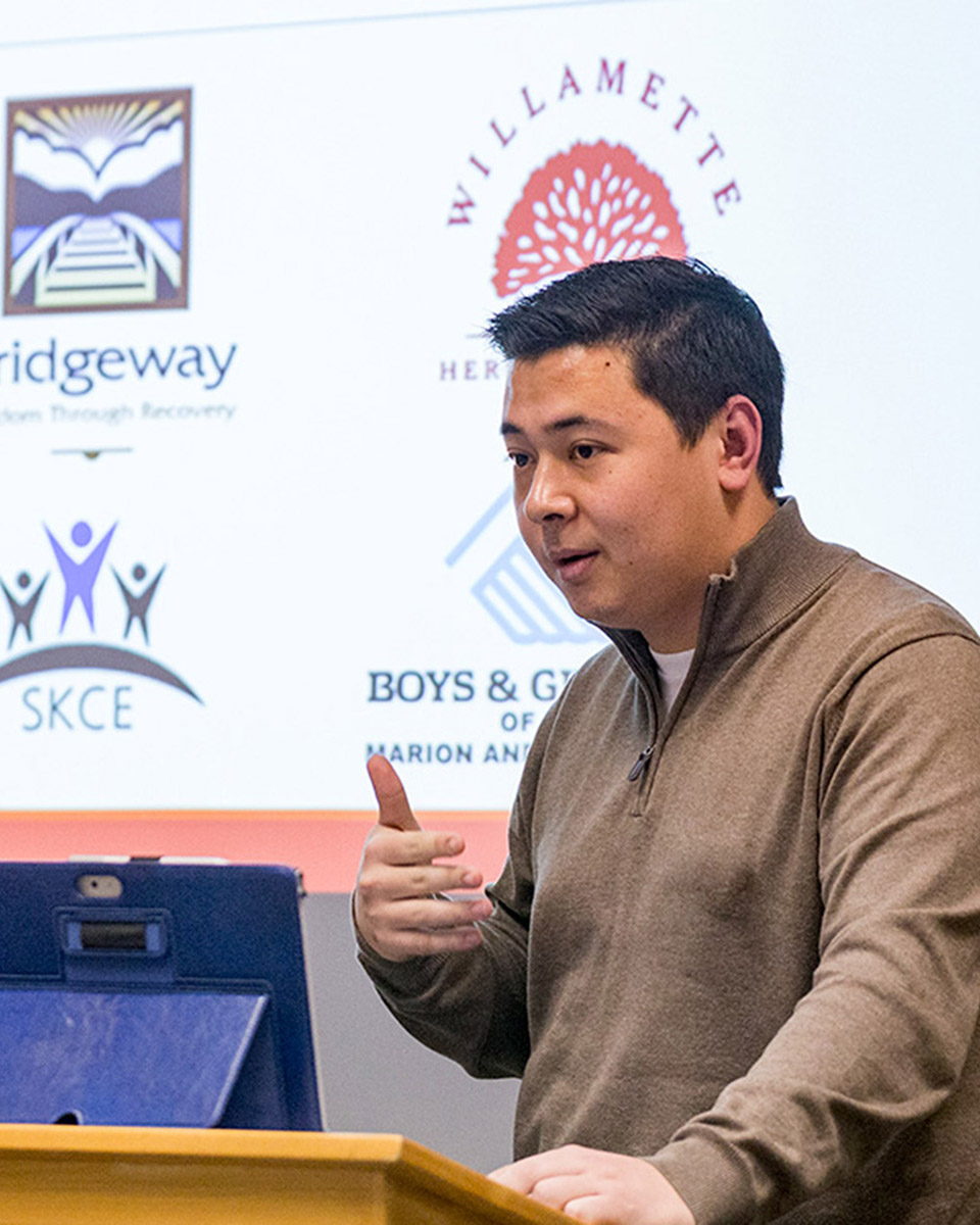 A person giving a presentation with a slide show in the background