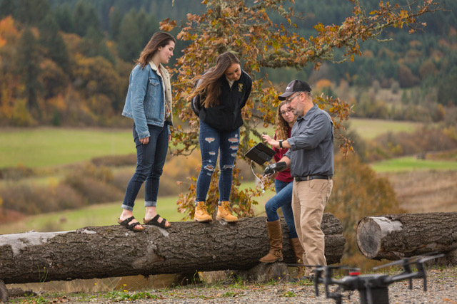 professor showing stduents an ipad that controls a drone