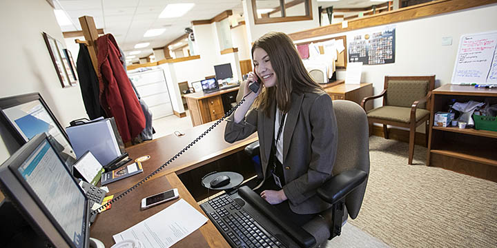 A student picking up the phone in an office