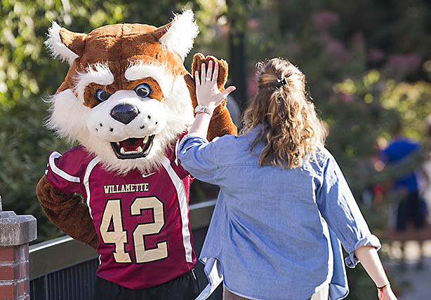 A student high-living the Willamette Bearcat mascot