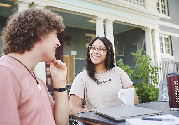 Two people chatting at an outdoor table