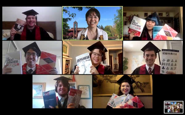 Seven students with a professor on a virtual call wearing graduation hats