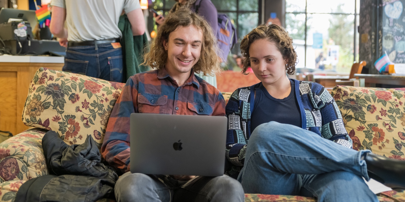 Two people looking at a laptop while sitting in the Bistro