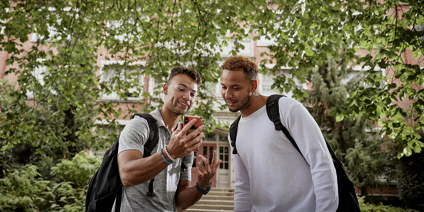two Willamette students outside looking at a phone