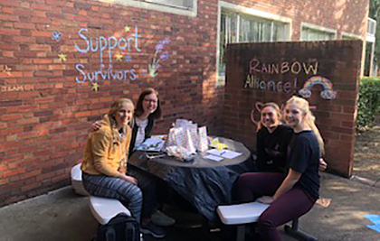 students sitting at a table outside